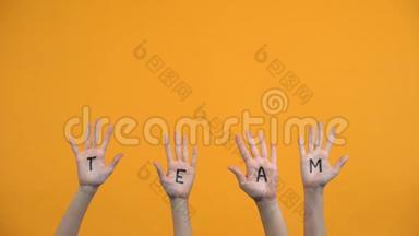 团队在橙色背景上写手掌，团结合作，小组团结